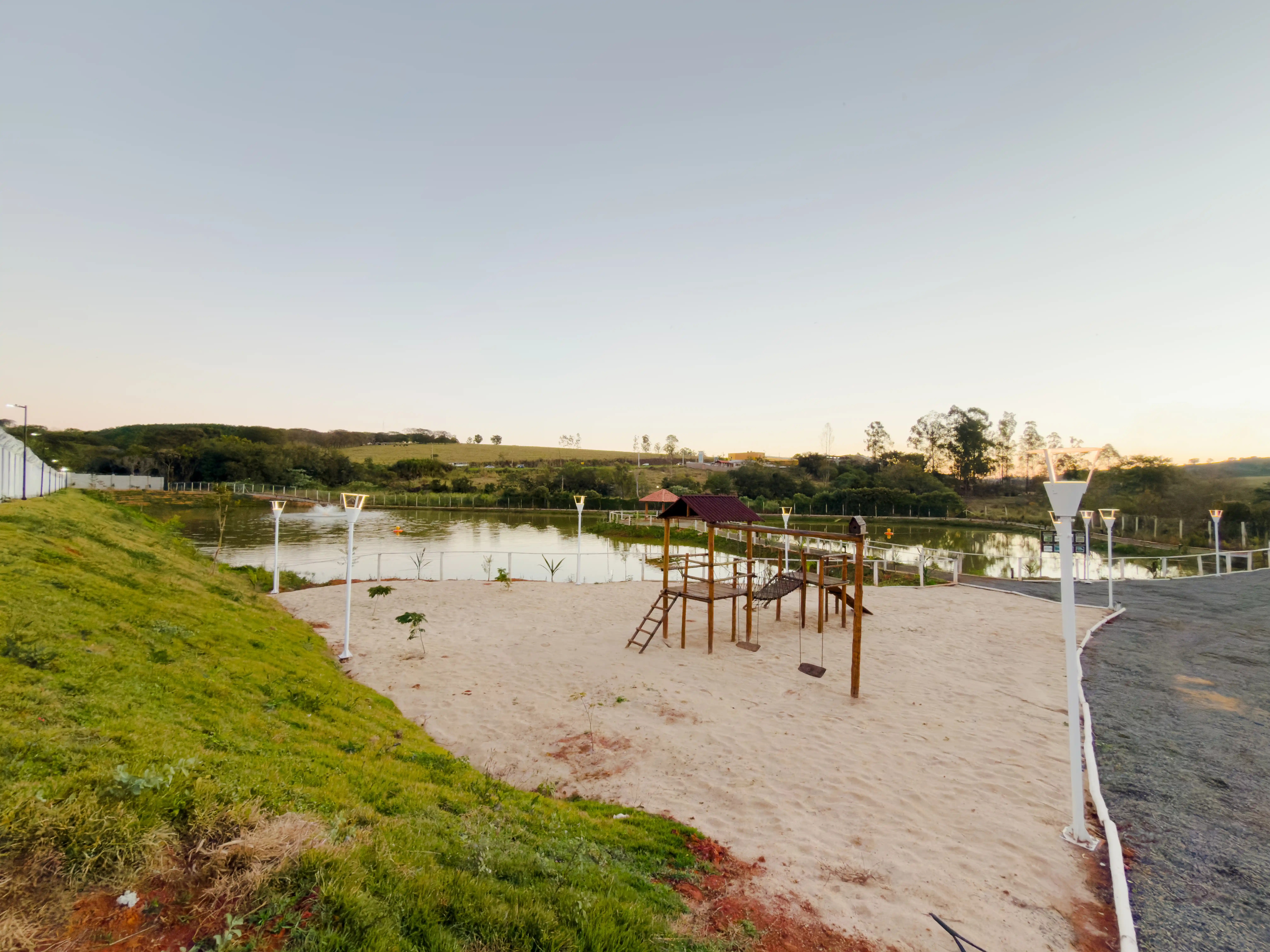 Playground com areia e lago ao entardecer no Villa Real